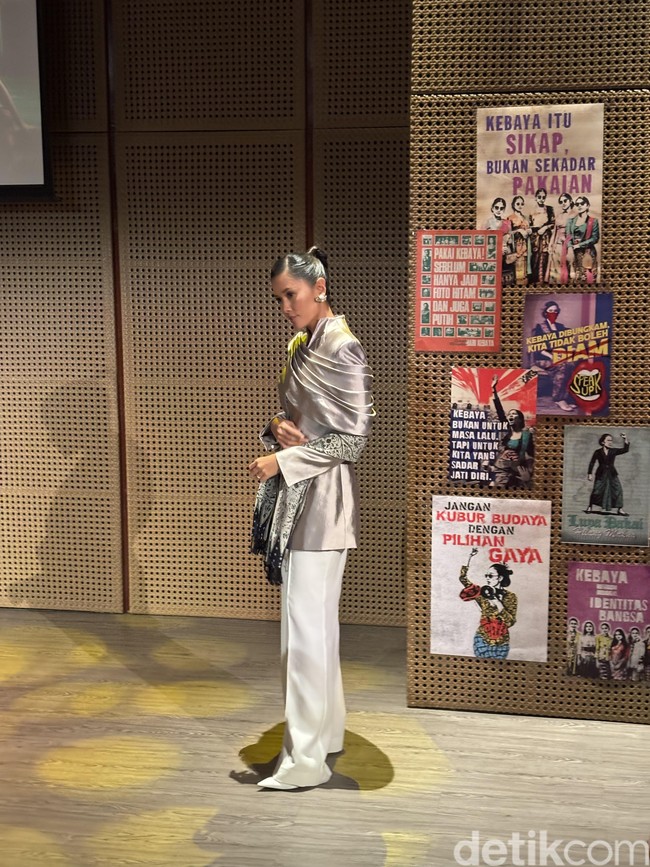 Titi memilih gaya rambut sleek bun yang membuat penampilannya terlihat rapi dan clean. Titi juga mengenakan sepasang anting berwarna silver yang senada. Foto: Vina Oktiani/Wolipop