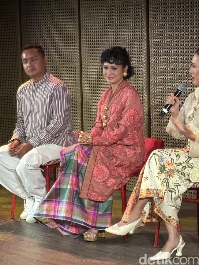 Andien memilih kebaya panjang warna peach kecoklatan dengan potongan lurus yang menjuntai hingga ke betis. Kebaya tersebut memiliki motif bordir besar berbentuk bunga dan dedaunan. Kebaya tersebut dipadukan dengan kain wastra nusantara motif kotak-kotak. Foto: Vina Oktiani/Wolipop