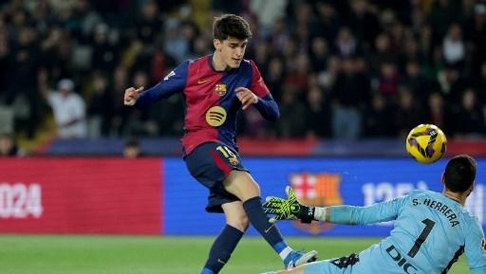 Barcelonas Spanish forward #18 Pau Victor Delgado and Osasunas Spanish goalkeeper #01 Sergio Herrera Piron fight for the ball during the Spanish league football match between FC Barcelona and CA Osasuna at Estadi Olimpic Lluis Companys in Barcelona on March 27, 2025. (Photo by LLUIS GENE / AFP)