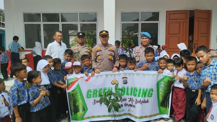 Polisi di Dumai mengajak anak-anak SD menanam pohon.