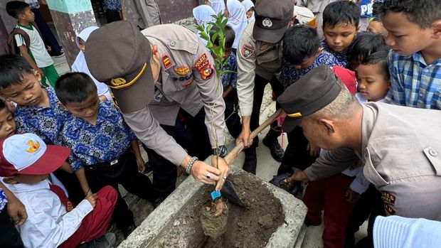 Polisi di Dumai mengajak anak-anak SD menanam pohon.