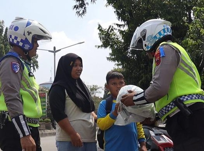 Satlantas Polres Pemalang membagikan helm gratis kepada anak sekolah, Rabu (23/7/2025).