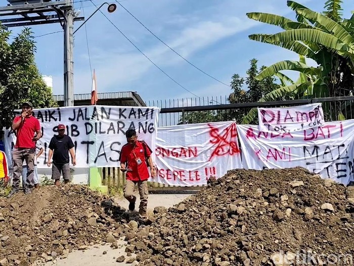 Warga Desa Tanjungrejo, Margoyoso, Kabupaten Pati menggelar aksi demo menutup pintu masuk pabrik beton, Rabu (23/7/2025).