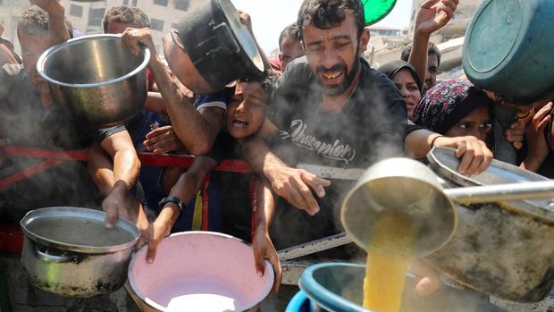 Warga Palestina menanti jatah makanan dari dapur amal di Gaza. Krisis kelaparan terus memburuk di tengah konflik berkepanjangan.