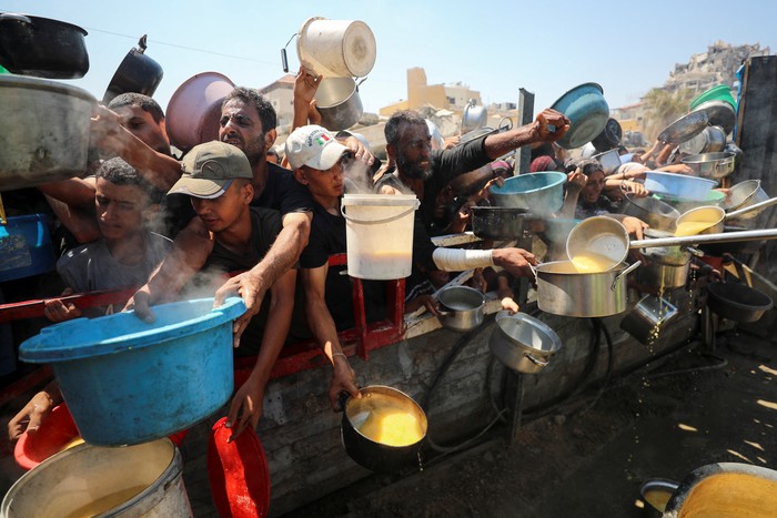 Warga Palestina menanti jatah makanan dari dapur amal di Gaza. Krisis kelaparan terus memburuk di tengah konflik berkepanjangan.