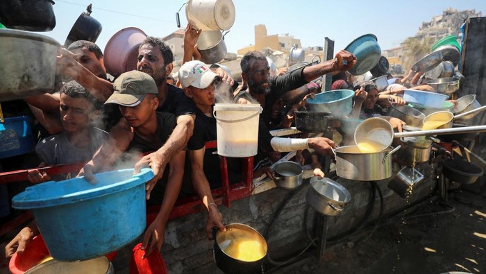 Warga Palestina menanti jatah makanan dari dapur amal di Gaza. Krisis kelaparan terus memburuk di tengah konflik berkepanjangan.