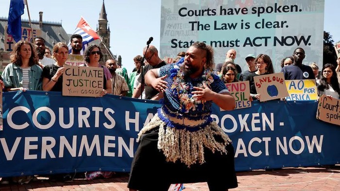 Aktivis dan juru kampanye iklim hadir di Den Haag, Belanda, untuk mendengarkan pengadilan menyampaikan pendapatnya. (Reuters: Marta Fiorin)