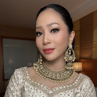 Riasan wajah Bunga tampil sempurna dengan complexion matte bercahaya, mata tegas dengan eyeliner winged, dan lipstik warna coral-pink. Rambutnya ditata sleek ke belakang, membuat perhiasan di area wajah tampak maksimal. Foto: dok. Instagram @bungazainal05