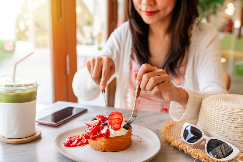 Young Asian woman enjoy eating dessert in cafe on summer vacation trip