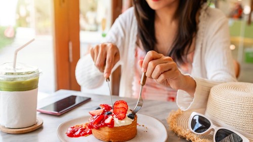 Young Asian woman enjoy eating dessert in cafe on summer vacation trip