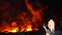 Warga merekam kebakaran pabrik minyak goreng (Foto: ANTARA FOTO/Yudi Manar)