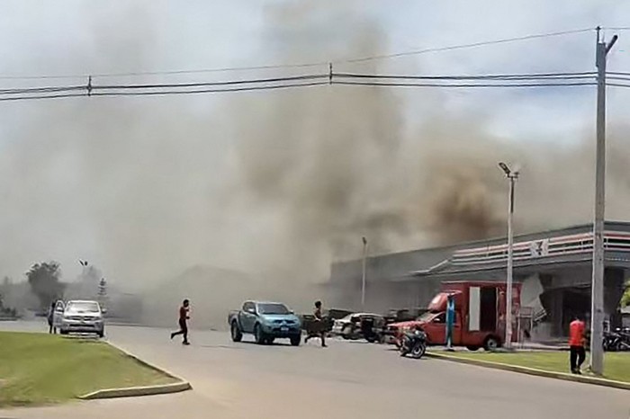 This frame grab from UGC video footage taken and posted on Facebook by Chatchak Ratsamikaeo on July 24, 2025 shows smoke billowing from the roof of a convenience store attached to a petrol station in Sisaket province after it was hit by a rocket strike from Cambodia. Thailand launched air strikes on Cambodian military targets on July 24 as Cambodia fired rockets and artillery, killing at least 11 civilians, in a dramatic escalation of a long-running border row between the two neighbours. (Photo by Courtesy of Facebook user Chatchak Ratsamikaeo / AFP) / -----EDITORS NOTE --- RESTRICTED TO EDITORIAL USE - MANDATORY CREDIT 