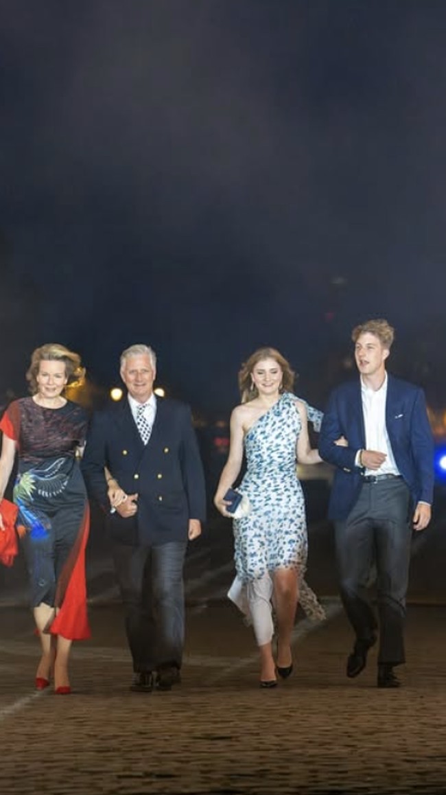 Malam harinya, saat menghadiri konser serta pertunjukan kembang api, penampilan Putri Mahkota kembali berubah. Bersama keluarga kerajaan, putri sulung Raja Philippe dan Ratu Mathilde itu mengenakan gaun one-shoulder rancangan desainer Victoria Beckham. Foto: dok. Instagram @belgianroyalpalace