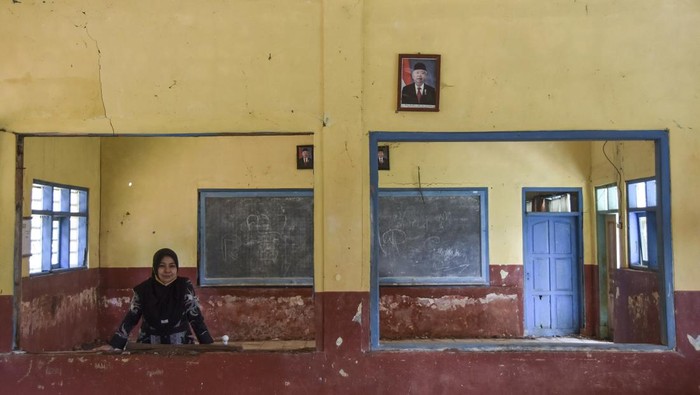 Sekolah Rusak Tak Diperbaiki, Siswa Belajar di Kelas Sekat Triplek Seorang guru membersihkan ruang kelas yang rusak di SD Negeri Mandalawangi, Desa Lengkongbarang, Kecamatan Cikatomas, Kabupaten Tasikmalaya, Jawa Barat, Kamis (24/7/2025). Sekolah Inpres yang dibangun tahun 1976 itu memiliki 90 siswa diantaranya kelas III sampai kelas VI yang menggunakan ruang kelas dengan sekat triplek (dua kelas mengisi satu ruang) akibat tiga ruang kelas rusak parah sejak tiga tahun lalu. ANTARA FOTO/Adeng Bustomi/foc.