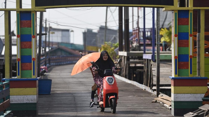 Sepeda Listrik Jadi Andalan Warga Daerah Terpencil Warga mengendarai sepeda listrik di Desa Muara Enggelam, Muara Wis, Kutai Kartanegara, Kalimantan Timur, Selasa (22/7/2025). Sepeda listrik menjadi transportasi alternatif bagi warga untuk menghemat penggunaan bahan bakar minyak (BBM) yang pasokannya terbatas pada desa tanpa daratan tersebut. ANTARA FOTO/M Risyal Hidayat/rwa.
