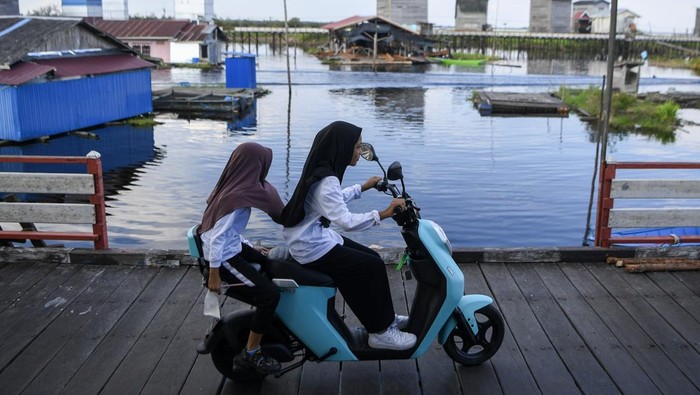 Sepeda Listrik Jadi Andalan Warga Daerah Terpencil Warga mengendarai sepeda listrik di Desa Muara Enggelam, Muara Wis, Kutai Kartanegara, Kalimantan Timur, Selasa (22/7/2025). Sepeda listrik menjadi transportasi alternatif bagi warga untuk menghemat penggunaan bahan bakar minyak (BBM) yang pasokannya terbatas pada desa tanpa daratan tersebut. ANTARA FOTO/M Risyal Hidayat/rwa.