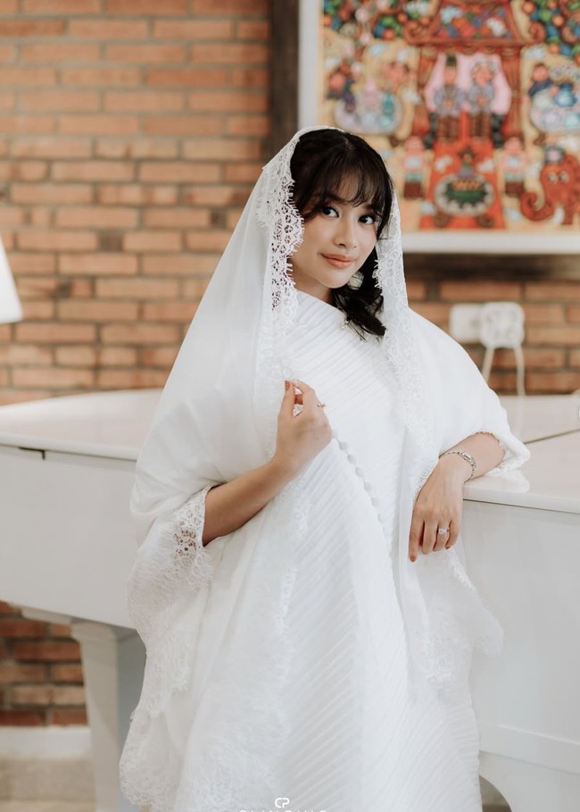 Adira anggun dalam balutan dress panjang putih dengan desain modern dan artistik. Tekstur plisket diagonal membentuk pola asimetris dari atas ke bawah. Potongan longgar dan flowy memberikan kesan anggun dan feminin. Foto: Instagram/@adirakania