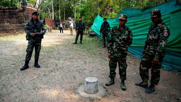 (FILES) Cambodian soldiers (R) and Thai soldier (L) stand guard at the disputed ancient Khmer temple Prasat Ta Muen Thom, or Prasat Ta Moan Thom in Khmer, on the Cambodian-Thai border in Oddar Meanchey province on March 26, 2025. Cambodian and Thai troops exchanged fire in a new round of clashes on July 24, 2025, hours after the two sides downgraded diplomatic relations in an escalating row over a disputed border. (Photo by TANG CHHIN Sothy / AFP)