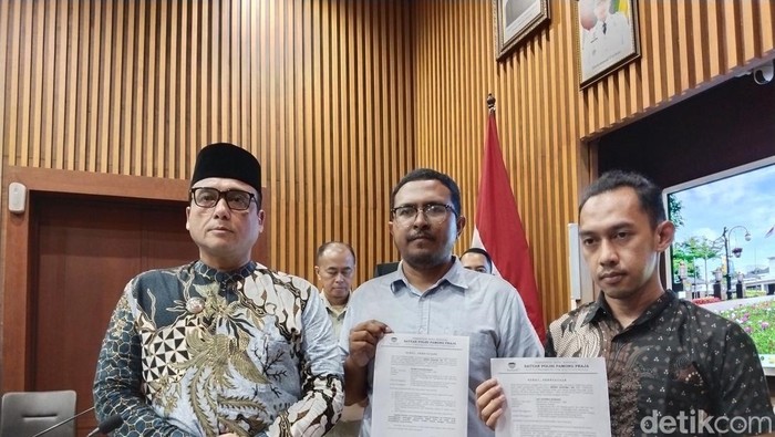 Wakil Wali Kota Bandung Erwin saat menunjukkan surat permohonan maaf dan sanksi denda kepada komunitas yang bagi-bagi bir di Pocari Run 2025.