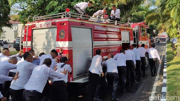 Anggota Damkar Satpol PP Boyolali mendorong truk Damkar usai menerima SK sebagai pegawai P3K, Jumat (25/7/2025).