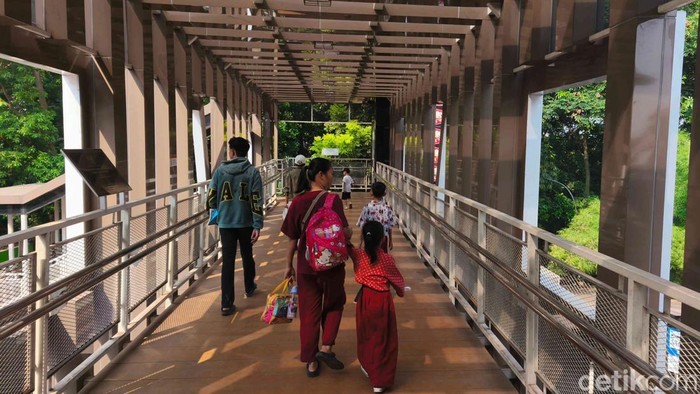 Sejumlah anak sekolah melintas di atas JPO Dukuh kawasan Kramat Jati, Jakarta Timur, Jumat (25/7/2025).