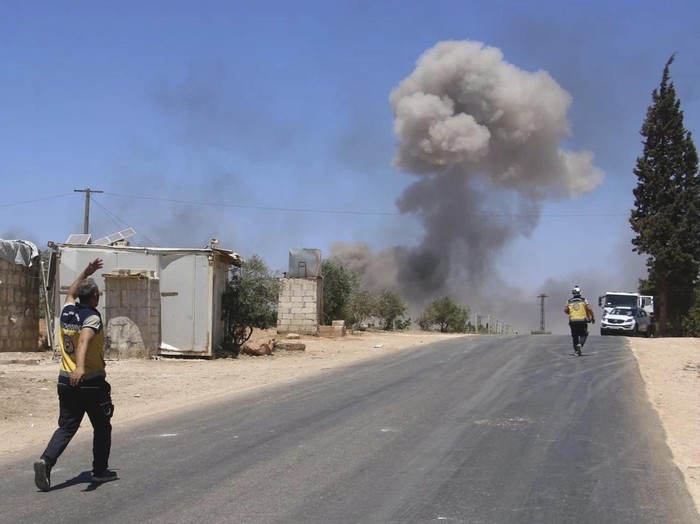 Kepulan asap menjulang ke udara dari lokasi gudang senjata yang diguncang serangkaian ledakan di Idlib, Suriah. (Syrian Civil Defense White Helmets via AP)