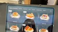 Layar menu digital di Tesla Diner menampilkan pilihan makanan klasik Amerika seperti burger, hot dog, dan kentang goreng dengan tampilan modern. Foto: Angela Yang / NBC News
