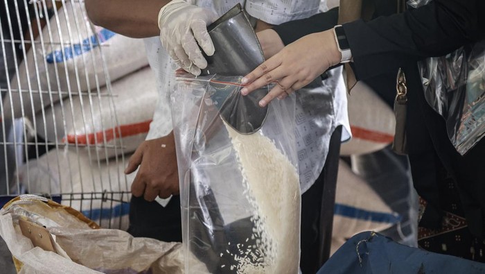 Petugas membawa contoh beras yang dijual saat melakukan inspeksi mendadak (sidak) di Pasar Induk Beras Cipinang, Jakarta, Jumat (25/7/2025). Sidak dilakukan untuk memeriksa harga dan kualitas beras pascatemuan sejumlah merek beras yang diduga tidak sesuai standar mutu dan takaran yang ditetapkan. ANTARA FOTO/Dhemas Reviyanto