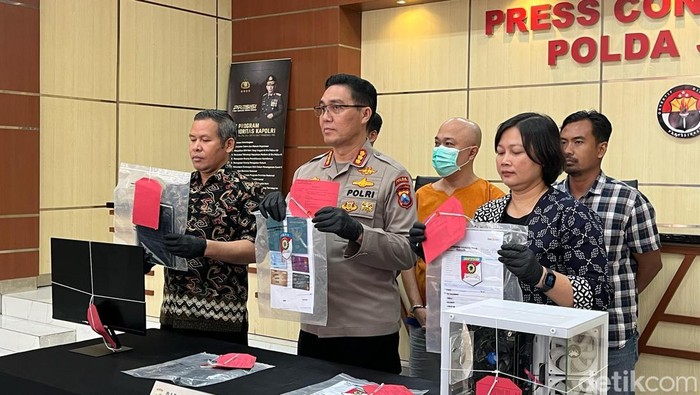 Polisi menunjukkan tersangka dan barang bukti pemberangkatan PMI Ilegal ke Jerman saat konferensi pers di Polda Jatim