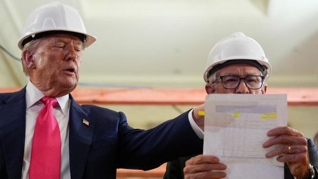 Presiden AS Donald Trump menunjuk sebuah dokumen saat Ketua Federal Reserve Jerome Powell memeriksa fakta angka-angka di dalamnya selama tur di gedung Dewan Federal Reserve, yang saat ini sedang direnovasi, di Washington, D.C., AS, 24 Juli 2025. (REUTERS/Kent Nishimura)