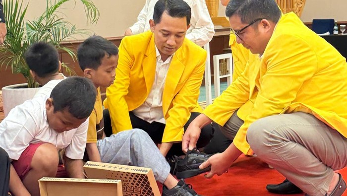 Ketua DPD Golkar Jateng Mohammad Saleh membagikan sepatu untuk anak-anak yang membutuhkan, Kamis (24/7/2025).