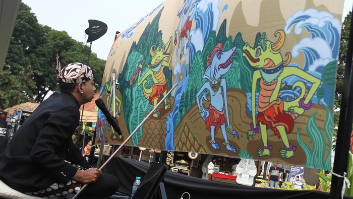 Wayang Beber yang Langka Dihidupkan Lagi Lewat Festival Tong-tong Market Pengunjung menonton pagelaran Wayang Beber dengan cerita legenda Suro dan Boyo yang dibawakan dalang Ki Dimas Febrian Astawira di Malang, Jawa Timur, Jumat (25/7/2025). Pertunjukan tersebut digelar di salah satu agenda Karisma Event Nusantara (KEN) yakni Festival Tong-tong Market sebagai upaya pelestarian Wayang Beber yang merupakan wayang tertua peninggalan masa Kerajaan Kediri dan kini semakin jarang dipentaskan serta dinilai terancam punah. ANTARA FOTO/Ari Bowo Sucipto/foc.
