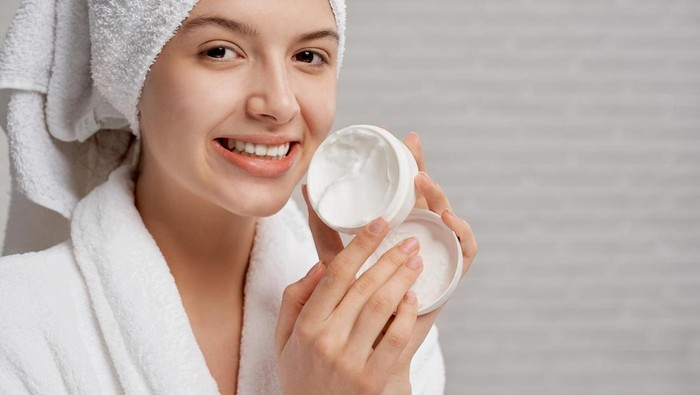 Seorang perempuan sedang mengaplikasikan basic skincare