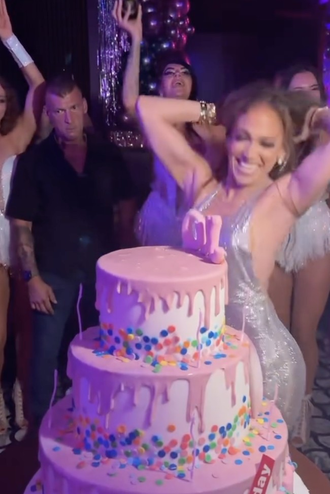 Suasana pesta kian meriah ketika staf klub mengangkat botol sampanye dan menghadirkan kue ulang tahun tiga tingkat berwarna pink-putih dengan nama “J.Lo” terpampang jelas di bagian tengah. Lagu terbarunya berjudul Birthday pun diputar, menghidupkan suasana dansa malam itu. (Foto: Instagram/@jlo)