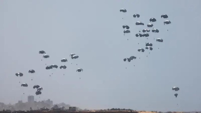Humanitarian aid falls through the sky towards the Gaza Strip after being dropped from an aircraft, amid the ongoing conflict between Israel and the Palestinian militant group Hamas, as seen from Israel, April 21, 2024. (Reuters)