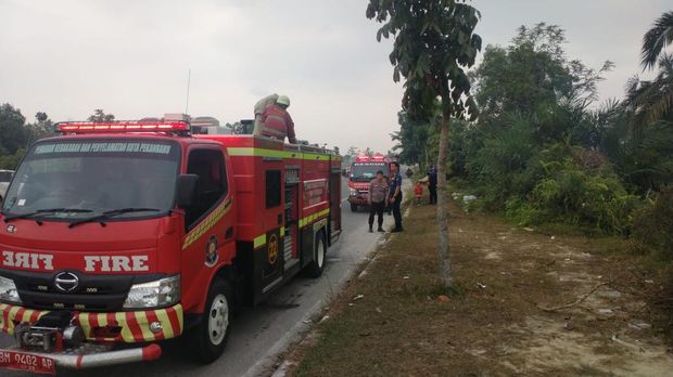 Polisi dan Damkar sigap memadamkan api yang membakar ilalang di Jalan Sudirman Ujung, Jumat (25/7/2025).
