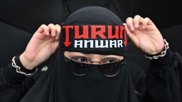 A protester wears a headband with the slogan that reads 