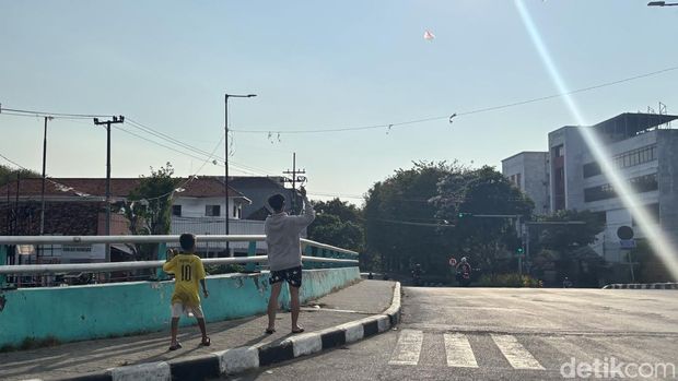 Anak-anak bermain layangan di jembatan kawasan Jalan Pasar Besar Wetan.