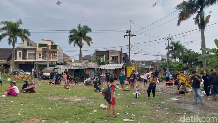 Anak-anak, remaja hingga orang dewasa ramai-ramai bermain layangan di Lapangan Kebo, Mangliawan, Malang.