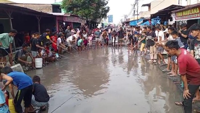 Aksi protes warga dengan memancing di kubangan jalan rusak di Kabupaten Deli Serdang (Istimewa)