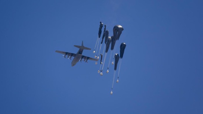 Langit Gaza Dipenuhi Parasut Bantuan Kemanusiaan An aircraft drops humanitarian aid packages over the Gaza Strip, as seen from Israel, July 27 2025. REUTERS/Amir Cohen BEST QUALITY AVAILABLE