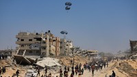 Warga di Gaza utara tampak menyaksikan dengan harap-harap cemas saat parasut-parasut bantuan melayang di langit, membawa makanan, obat-obatan, dan perlengkapan darurat. Sebagian besar bantuan menyasar wilayah yang terdampak paling parah oleh krisis, termasuk kamp-kamp pengungsi dan permukiman yang hancur. (REUTERS/Dawoud Abu Alkas)