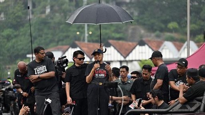 Malaysias former prime minister Mahathir Mohamad (C) speaks during a protest against Malaysias Prime Minister Anwar Ibrahim in Kuala Lumpur on July 26, 2025. Several thousand Malaysians took to the capitals streets to protest growing public discontent over rising living costs and a perceived lack of reform by Prime Minister Anwar Ibrahims unity government. (Photo by Mohd RASFAN / AFP)