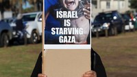 Protes berlangsung damai, dengan orasi dan nyanyian solidaritas mewarnai sepanjang jalan pesisir. Beberapa aktivis membawa ilustrasi visual yang menggambarkan penderitaan rakyat Gaza akibat kelaparan. (REUTERS/Esa Alexander)  