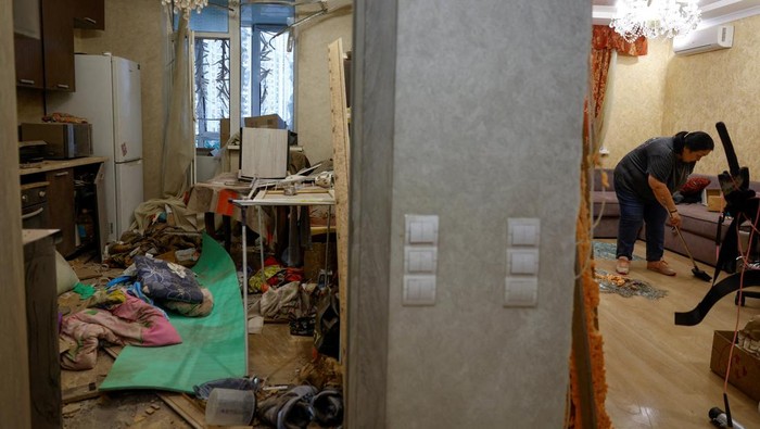 Apartemen Hancur, Warga Kyiv Bersihkan Puing Usai Serangan Drone Rusia Seorang wanita membersihkan puing-puing dari dalam apartemennya yang rusak akibat serangan pesawat tak berawak Rusia, di tengah serangan Rusia terhadap Ukraina, di Kyiv, Ukraina, Senin (28/7). REUTERS/Valentyn Ogirenko