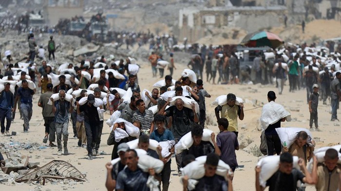 Palestinians carry aid supplies that entered Gaza through Israel, in Beit Lahia in the northern Gaza Strip,  July 27, 2025. REUTERS/Dawoud Abu Alkas
