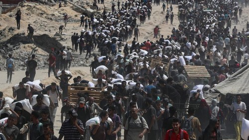 Palestinians carry aid supplies that entered Gaza through Israel, in Beit Lahia, northern Gaza Strip, July 27, 2025. REUTERS/Mahmoud Issa