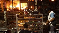 Kebakaran melanda Pasar Taman Puring, Jakarta Selatan, Senin (28/7/2025) malam. Pedagang berusaha menyelamatkan dagangannya.
