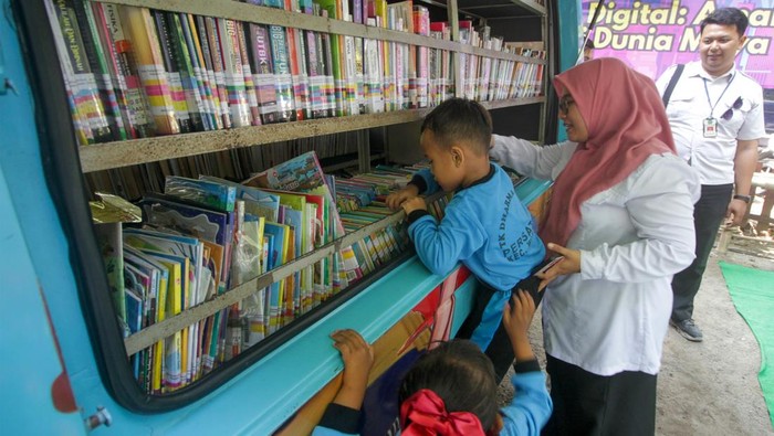Perpustakaan Keliling di Sidoarjo Dorong Minat Baca Anak Petugas mendampingi anak memilih buku di Mobil Perpustakaan Keliling di Sidoarjo, Jawa Timur, Senin (28/7/2025). Kegiatan perpustakaan keliling tersebut bertujuan meningkatkan minat literasi anak, memperluas pengetahuan dan menumbuhkan rasa cinta buku. ANTARA FOTO/Umarul Faruq