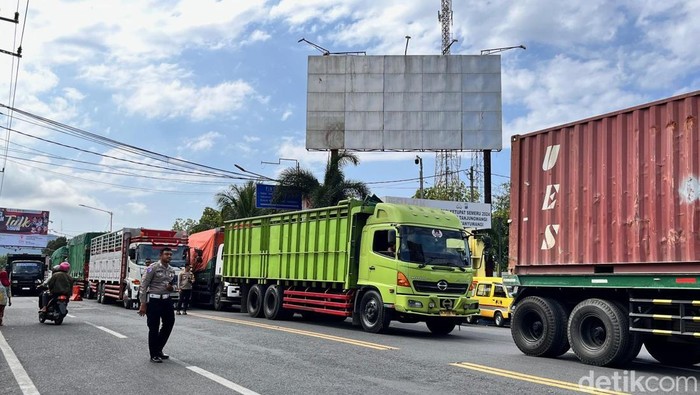 Petugas kepolisian mengatur kendaraan masuk ke dalam area parkir pelabuhan ASDP Ketapang Banyuwangi